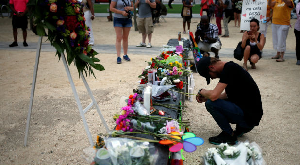 Man prays for the deceased ahead of candlelight vigil for victims of mass shooting in Orlando, Florida.