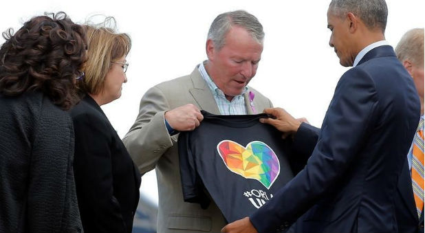 U.S. President Barack Obama receives a t-shirt from Mayor of Orlando Buddy Dyer (C) as he arrives in Orlando to meet with families of victims of the Pulse nightclub shooting, in Florida.