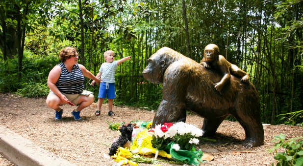 A mother and her child visit a bronze statue of a gorilla outside the Cincinnati Zoo's Gorilla World exhibit.