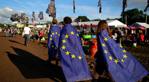 Revelers wrapped in European Union flags walk at Worthy Farm in Somerset during the Glastonbury Festival, Britain.