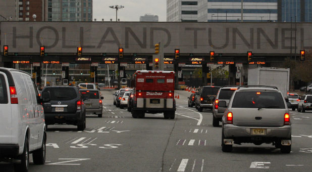 Three people were arrested on Tuesday morning with several rifles and handguns, some loaded, after police stopped them near the Holland Tunnel in New Jersey, authorities said.