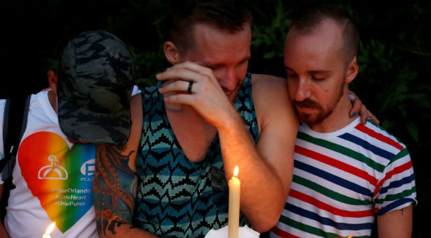 A man cries while his friends comfort him as they take part in a vigil for the Pulse night club victims following last week's shooting in Orlando