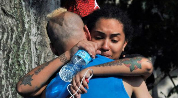 Friends and family members embrace outside the Orlando Police Headquarters during the investigation of a shooting at the Pulse nightclub in Orlando, Florida