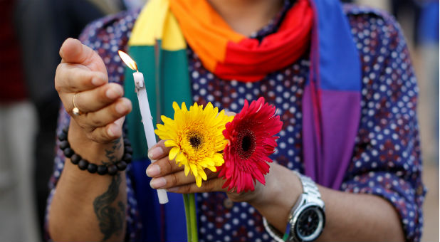A participant holds a candle during a vigil in memory of the victims of the Pulse gay nightclub shooting in Orlando.