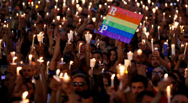 eople take part in a candlelight memorial service the day after a mass shooting at the Pulse gay nightclub in Orlando