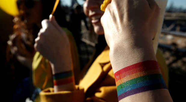 People wear rainbow tattoos on the Brooklyn Bridge in New York during a gathering to remember the victims of the mass shooting in Orlando.