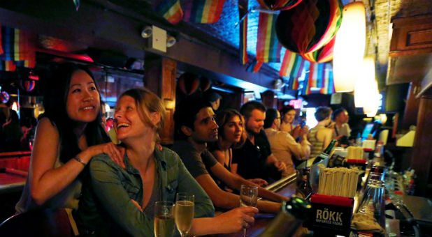 Patrons watch coverage of the U.S. Supreme Court ruling on the Defense of Marriage Act at the Stonewall Inn in New York June 26, 2013.