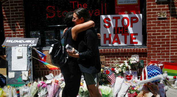Matti Mejia (L) and Shaina Roberts embrace after laying flowers at a memorial outside The Stonewall Inn in New York.