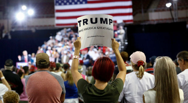 A woman holds up a campaign sign as Republican U.S. Presidential candidate Donald Trump speaks at a rally
