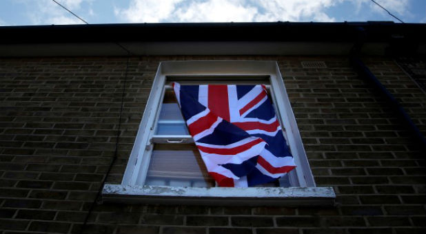 A British flag flutters in front of a window in London.