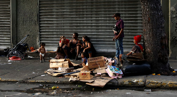 People stand on a street in Caracas, Venezuela.