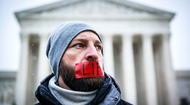 Bound4Life international's Matt Lockett prays outside the Supreme Court to end abortion.