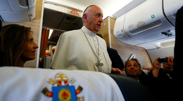 Pope Francis speaks on the plane as he travels from Italy to Poland