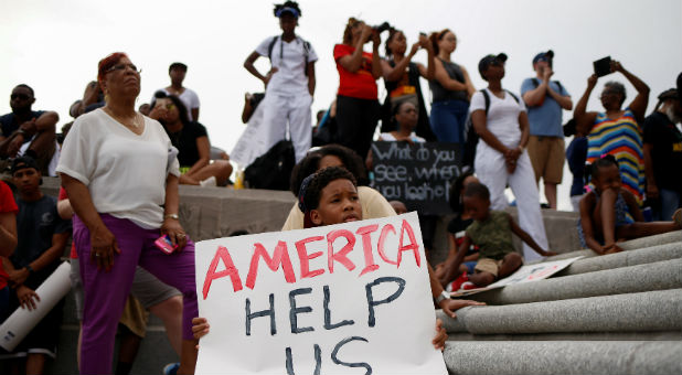 Kerron Stewart, 10, sits with demonstrators on the steps of the Louisiana State Capitol building in Baton Rouge, Louisiana, U.S.