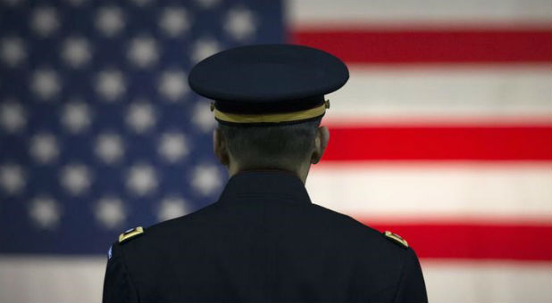 A U.S. Army officer listens to a speaker with the U.S. flag in the background at the Hiring our Heroes job fair in New York