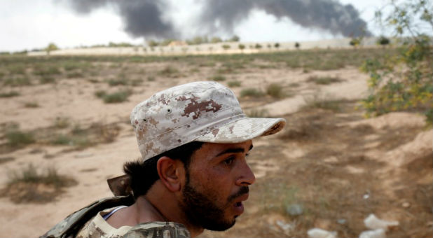 A member of the Libyan forces allied with the U.N.-backed government looks at Islamic State fighters' positions during a battle in Sirte.