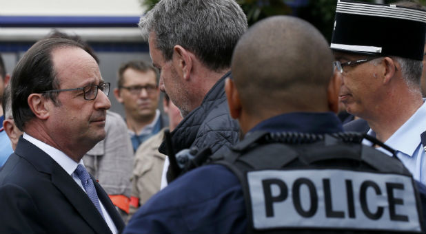 French President Francois Hollande (L) speaks with police forces after two assailants had taken five people hostage in the church at Saint-Etienne-du -Rouvray near Rouen in Normandy, France.