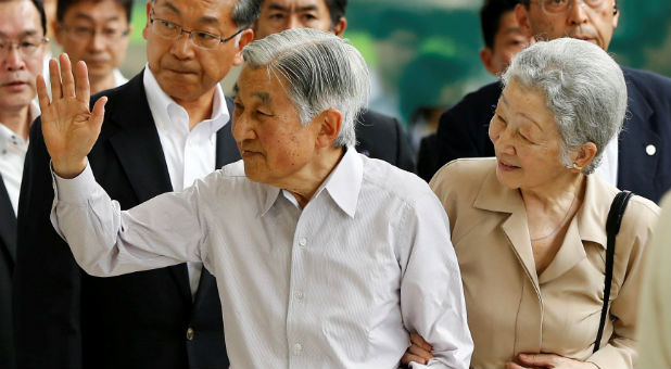Japan's Emperor Akihito (L), flanked by Empress Michiko, waves to well-wishers as they board a Shinkansen bullet train to depart to their imperial summer villa in Nasu, at Tokyo station in Tokyo, Japan