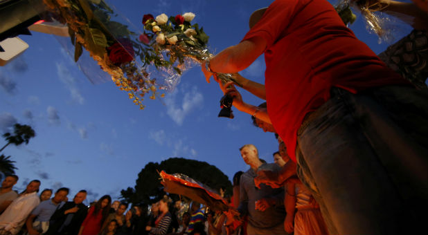 People gather to leave flowers in tribute to victims the day after a truck ran into a crowd at high speed killing scores and injuring more on the Promenade des Anglais who were celebrating the Bastille Day national holiday, in Nice, France