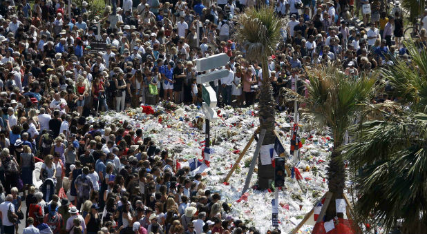A view shows the crowd gathering near a makeshift memorial on the Promenade des Anglais during a minute of silence on the third day of national mourning to pay tribute to victims of the truck attack along the Promenade des Anglais on Bastille Day that killed scores and injured as many in Nice, France
