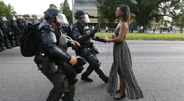 A demonstrator protesting the shooting death of Alton Sterling is detained by law enforcement near the headquarters of the Baton Rouge Police Department in Baton Rouge, Louisiana.