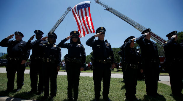 Police officers salute the hearse as they attend the funeral of slain Dallas police Sgt. Michael Smith in Dallas