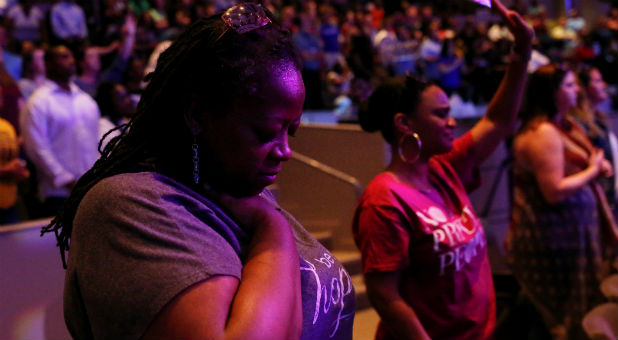 People stand during a prayer service at the Concord Baptist Church in Dallas, Texas.