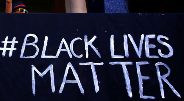 A protester raises her fist during a rally organised to show support for the 'Black Lives Matter' movement,