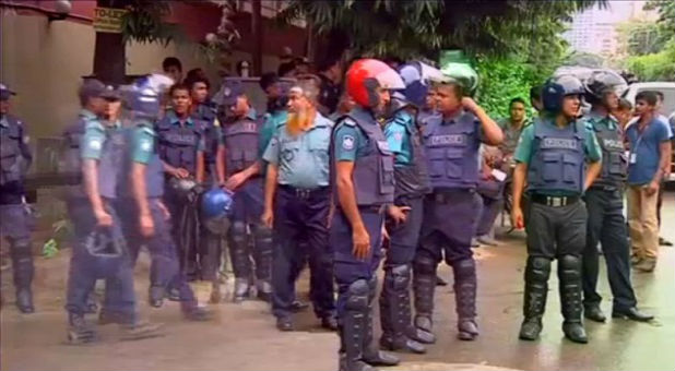 Police gather after gunmen attacked the Holey Artisan restaurant and took hostages early Saturday in Dhaka, Bangladesh.