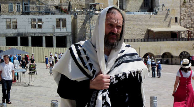 A Jewish man by the Western Wall in Jerusalem wearing a Tallit