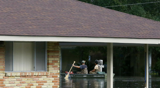 Residents use a boat to navigate through flood waters in Ascension Parish, Louisiana