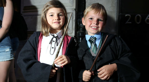 Fans in costume queue at an event to mark the release of the book of the play of Harry Potter and the Cursed Child parts One and Two at a bookstore in London