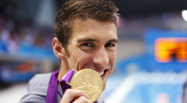 Michael Phelps of the U.S. poses with his gold medal after winning the men's 4x100m medley relay final during the London 2012 Olympic Games