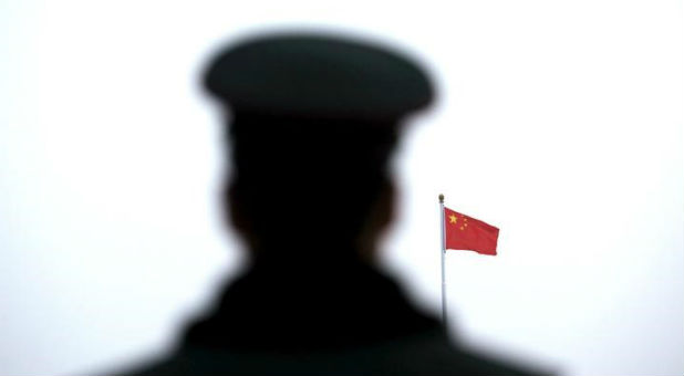 A paramilitary policeman watches a flag-raising ceremony at Tiananmen Square ahead of the opening session of the National People's Congress (NPC) in Beijing, China
