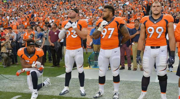 Denver Broncos inside linebacker Brandon Marshall (left) kneels during the national anthem.
