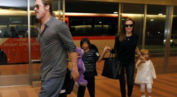 Hollywood actors Brad Pitt (L) and actress Angelina Jolie (2nd R) arrive with their children Knox (beside Pitt), Vivienne (R) and Pax (C) at Haneda international airport in Tokyo, Japan on July 28, 2013.