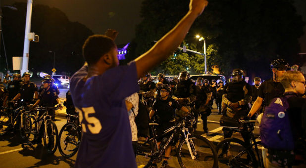 Demonstrators protesting the police shooting of Keith Scott are kept out of a wealthy neighborhood by police after marching from downtown Charlotte