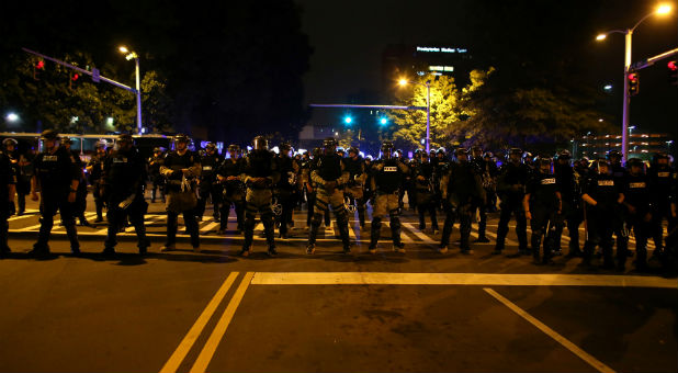 Police in riot gear block a roadway to stop demonstrators from entering a neighborhood as they protest the police shooting of Keith Scott in Charlotte