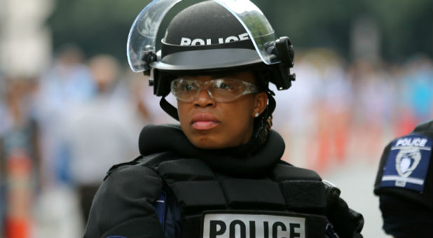 A female police officer wears riot gear as she stands in position outside a football game in Charlotte, North Carolina.