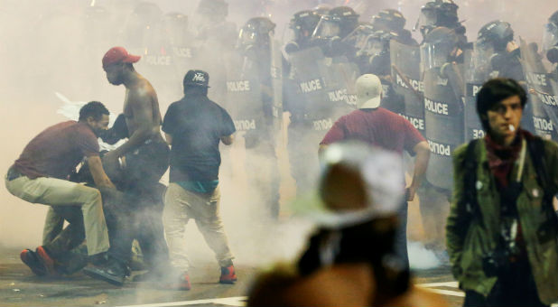 People maneuver amongst tear gas in uptown Charlotte, NC during a protest of the police shooting of Keith Scott
