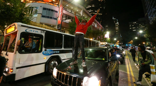 A man stands on a car in uptown Charlotte, NC to protest the police shooting of Keith Scott, in Charlotte, North Carolina.