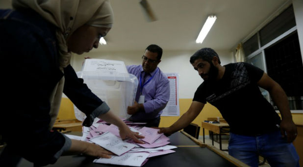 Officials count ballots after polls closed at a polling station for parliamentary elections in Amman, Jordan