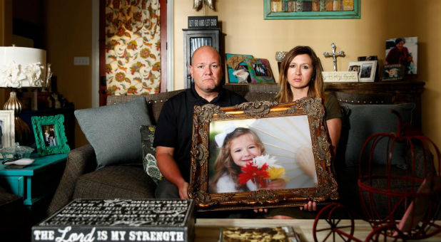 Kelly and Ryan Breaux sit holding a portrait of their deceased daughter Emma Breaux in their home in Breaux Bridge, Louisiana, on June 16, 2016. The husband and wife lost twins, Emma and Talon, to different superbugs that they contracted while in the neonatal unit at Lafayette General Hospital.