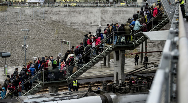 Police organize a line of refugees on a stairway leading up to trains arriving from Denmark at the Hyllie train station outside Malmo, Sweden