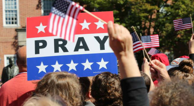 An attendee holds a prayer sign at a Decision America tour stop.