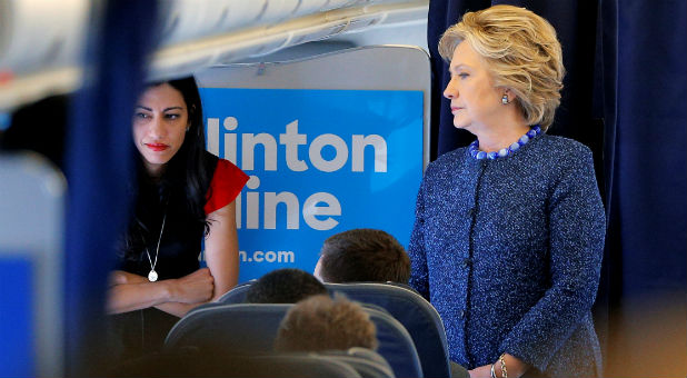 U.S. Democratic presidential nominee Hillary Clinton talks to staff members, including aide Huma Abedin (L), onboard her campaign plane in White Plains, New York