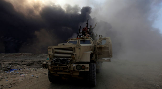Iraqi army personnel ride on a military vehicle in Qayyarah, during an operation to attack Islamic State militants in Mosul, Iraq, Oct. 19, 2016.