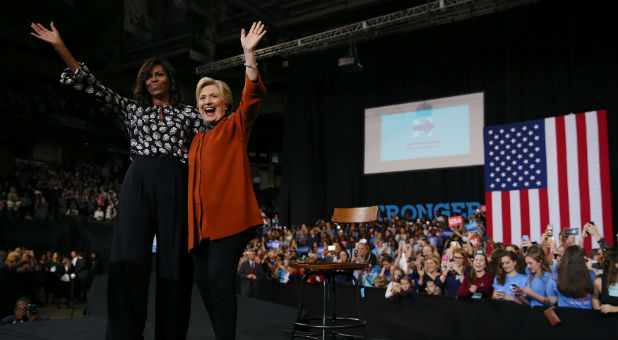 First lady Michelle Obama (L) and U.S. Democratic presidential candidate Hillary Clinton wave after a campaign rally in Winston-Salem, North Carolina