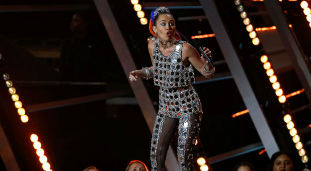 Show host Miley Cyrus speaks on stage at the 2015 MTV Video Music Awards in Los Angeles