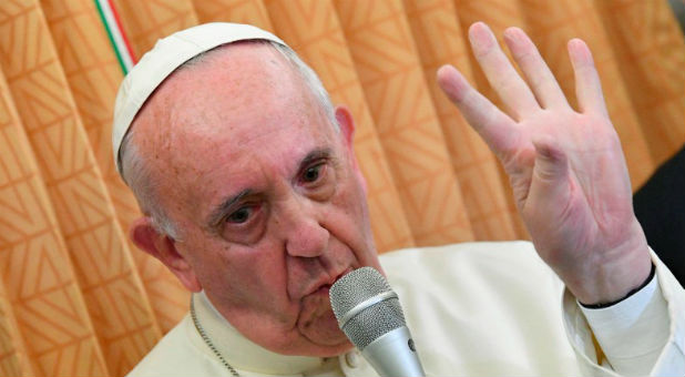 Pope Francis gestures as he speaks to journalists on his flight back to Rome following a visit in Georgia and Azerbaijan